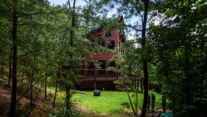 A cabin surrounded by dense forest, with a visible deck and a small gazebo. - 2BR 2BTH PRIVATE, HOT TUB POOL TABLE (Sevierville)