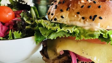En sandwich med salat, tomat og ost, samt en salat og pommes frites.