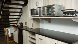Una cucina con piano di lavoro nero, elettrodomestici in acciaio inossidabile e mobili in legno.