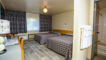 Une chambre d’hôtel avec deux lits, un bureau avec une lampe, une fenêtre avec des rideaux, une douche et une salle de bain avec une baignoire.