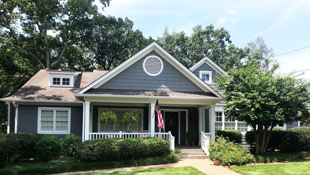 A two-story house with a front porch, a small garden, and a well-maintained lawn. - Walk to Death Valley! | Cozy Lakeside Suite (Clemson)