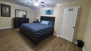 A bedroom with a bed, a ceiling fan, a dresser, a mirror, and a door. - COZY Private APARTMENT "3Bedroom/1Bathroom" (Conyers)