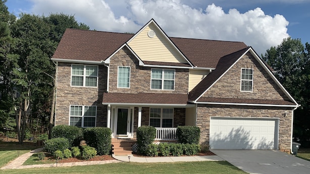 A two-story house with a stone facade, a front porch, and a garage. - COZY Private APARTMENT "3Bedroom/1Bathroom" (Conyers)