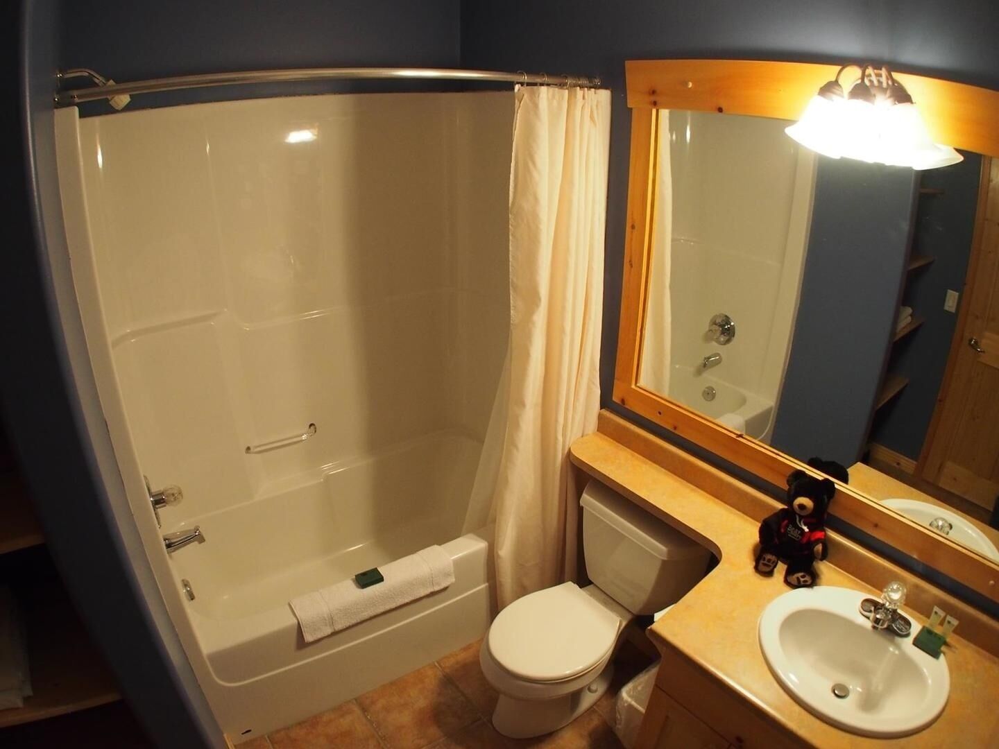 A bathroom with a bathtub, toilet, sink, and a mirror.