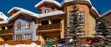 A hotel with multiple buildings, each with balconies and snow-covered roofs.