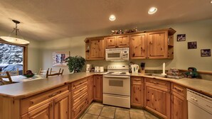 A kitchen with wooden cabinets, a stove, microwave, and a dishwasher.