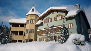 A large, multi-story building with a snow-covered roof and a tower.