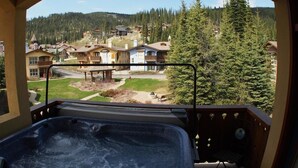 Un bain à remous avec vue sur un quartier résidentiel et une forêt.