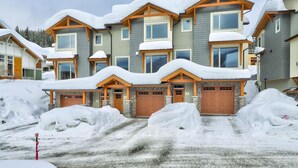 A multi-story residential building with a snow-covered roof and a stone facade. - Echo Landing#02 (Sun Peaks)