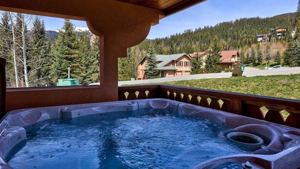A hot tub with a view of a mountain landscape and houses. - Crystal Forest #22 By Bear Country (Sun Peaks)