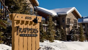 A wooden sign with 'Trappers Landing' and a lodge in the background. - Trappers Landing #11 (Sun Peaks)