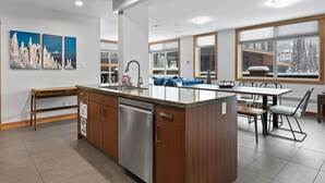 A modern kitchen with a central island, wooden cabinetry, and a stainless steel dishwasher.