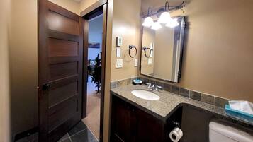 Une salle de bain avec un double lavabo, un grand miroir et un distributeur de serviettes.