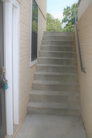 Stairs lead to an upper floor with a window and a door.