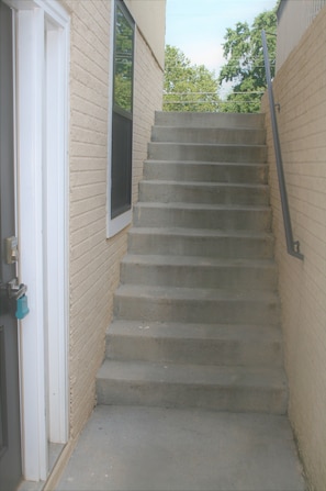 Stairs lead to an upper floor with a window and a door.