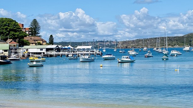 A marina with various boats docked, a sandy beach, and buildings in the background. - Manly Beach Retreat in walkable great location, with bonus rare onsite parking (Manly)