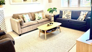 A living room with two sofas, a coffee table, and a potted plant. - Manly Beach Retreat in walkable great location, with bonus rare onsite parking (Manly)