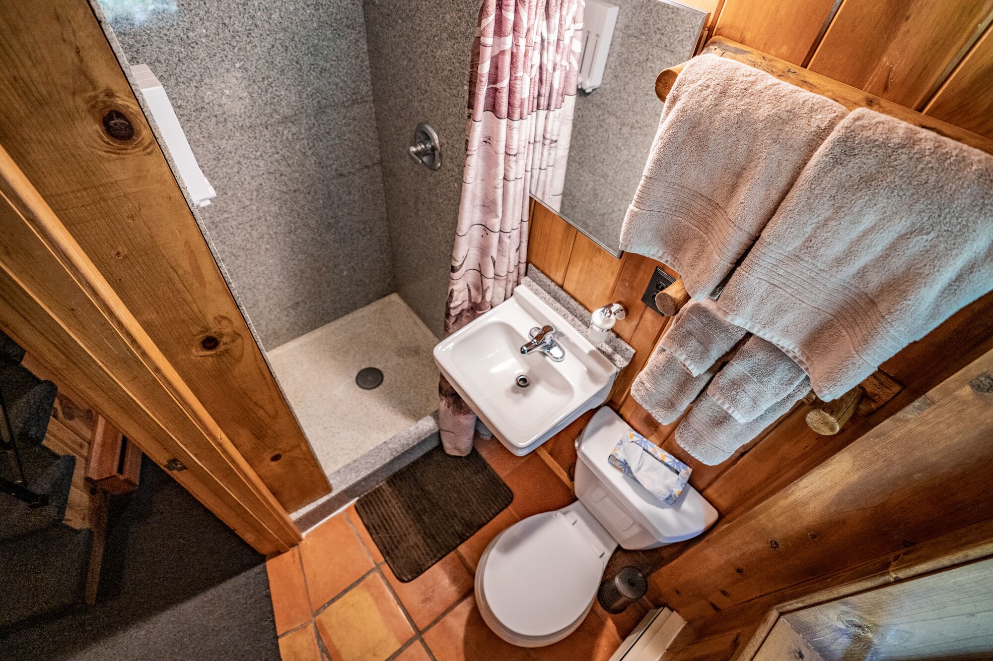 A compact bathroom with a shower, sink, and toilet.