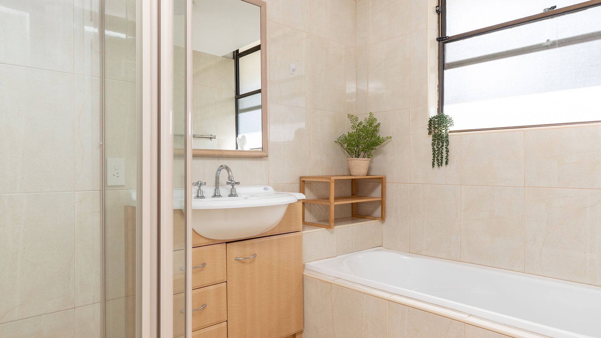 A bathroom with a sink, mirror, cabinet, and bathtub.