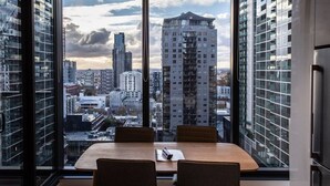 A modern office space with a large table and chairs, large windows offering a city view.