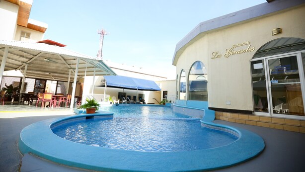 A swimming pool area with a covered seating area and a restaurant named 'Los Girasoles'. - Hotel Mansion Teodolinda (Managua)