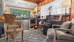 A cozy living room with a wooden ceiling, a fireplace, a sofa, and a coffee table. - 1 Mile Away from Volcano National Park (Volcano)