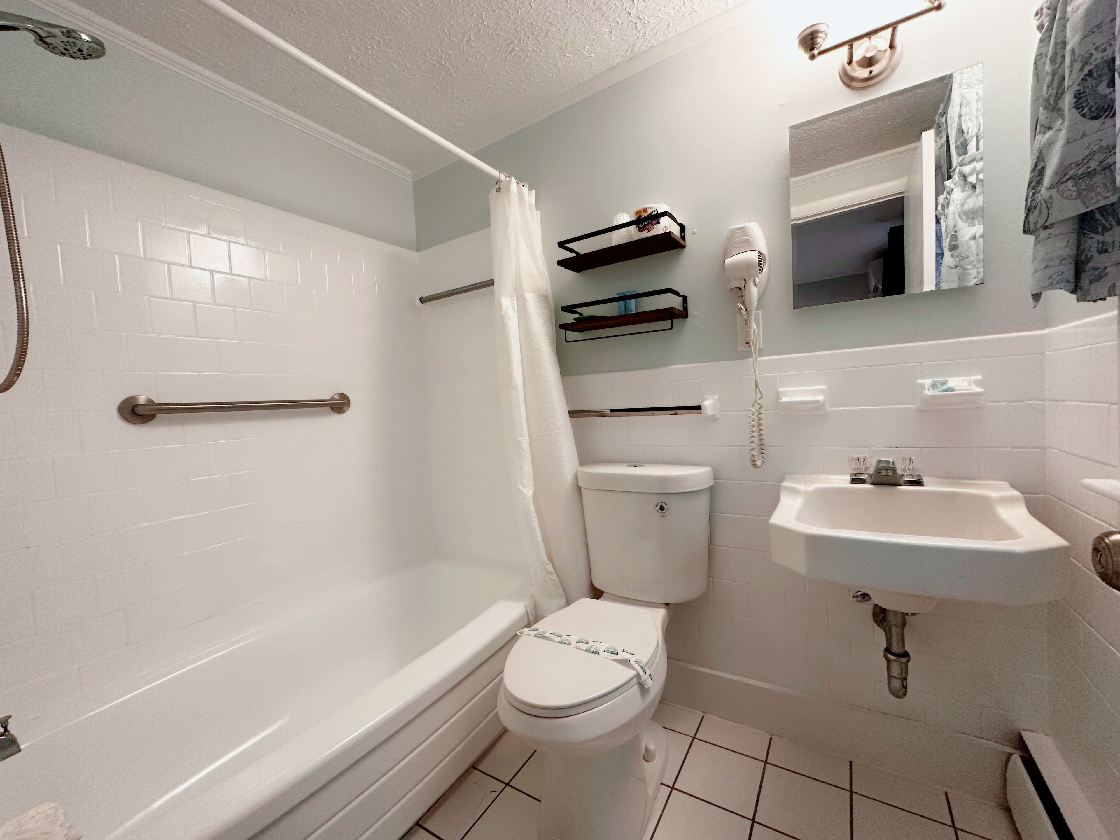 A bathroom with a bathtub, toilet, and sink.