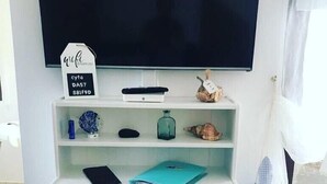 A white entertainment unit with a flat-screen TV, a decorative sign, and various items on shelves. - 2 bedroom detached villa with private pool in Ayia Thekla (Ayai thekla)