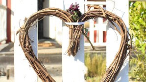 Ghirlanda a forma di cuore su una recinzione bianca.