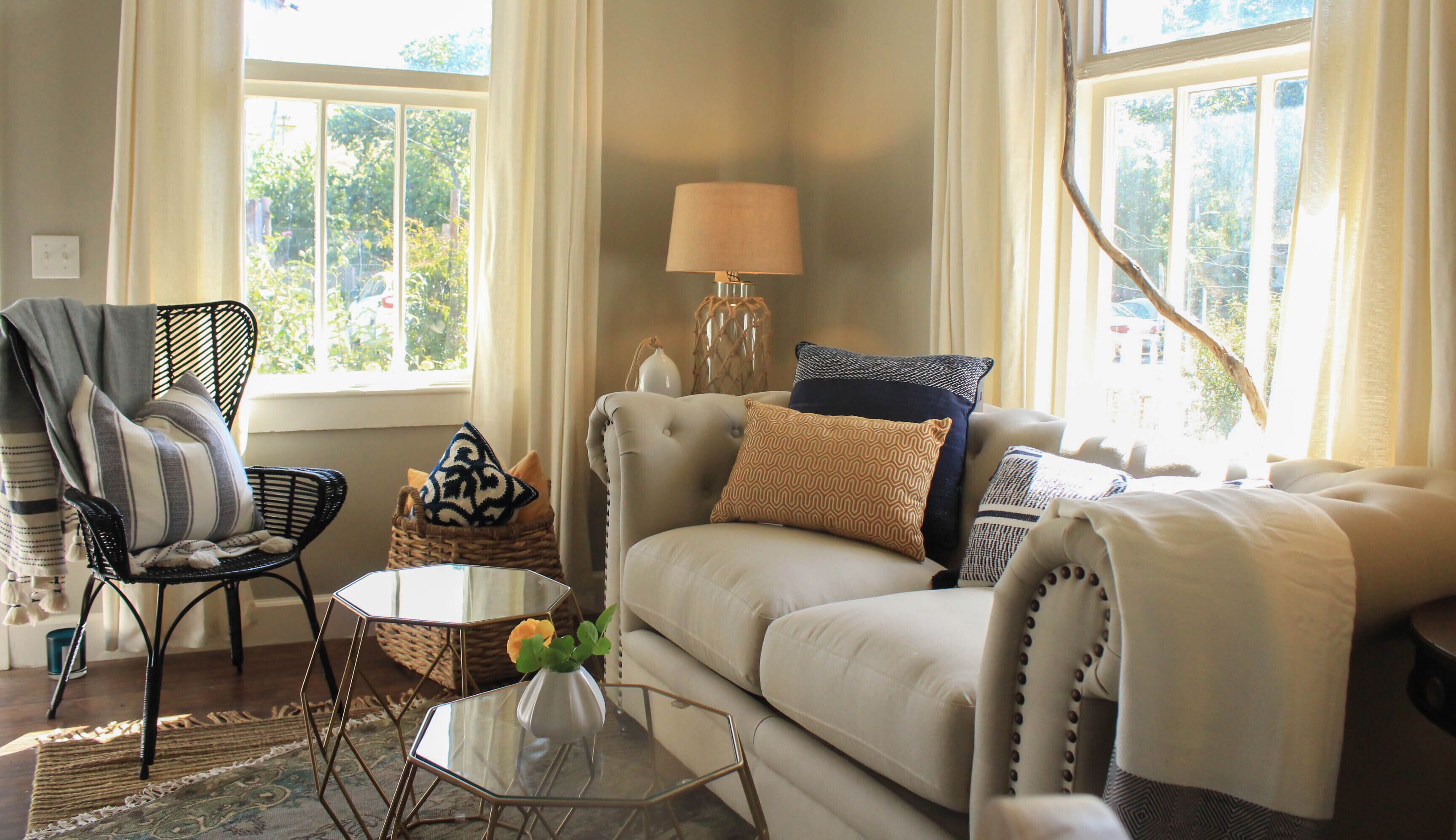 A living room with a sofa, armchair, and a small table with a vase.