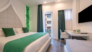 Una moderna camera d'albergo con un ampio letto, una scrivania e una televisione.