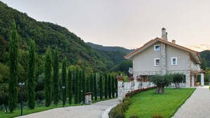 A stone house with a balcony, surrounded by a well-maintained garden and a gravel path leading to the entrance. - Maralè (Serino)