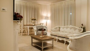 A spacious living room with a white sofa, a wooden coffee table, and a dining area with a table and chairs. - Maralè (Serino)