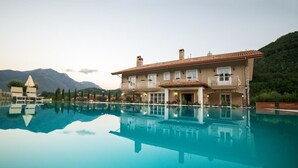 A large, two-story building with a swimming pool in front. - Maralè (Serino)