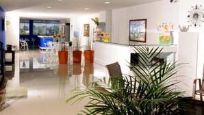 A modern kitchen with a glass island, white cabinets, and a view of the city. - Hotel Aussie Koala (Armenia)