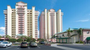 Un hôtel à plusieurs étages doté d’un atrium central, d’un parking et d’un petit bâtiment surmonté d’un toit végétalisé.