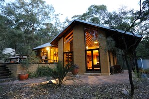 A two-story building with a balcony and a large window. - Corymbia Cottage – Broke's Secluded Escape (Broke)