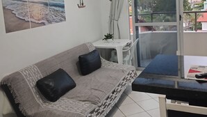 Una sala de estar con un sofá, una mesita y vistas al exterior.