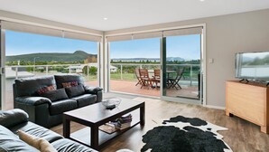 A modern living room with a leather sofa, a coffee table, and a TV stand.