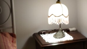 A bedside table with a lamp, a pillow, and a nightstand. - Oberdan Suites with Terrace (historical apartment in Alberobello) (Alberobello)