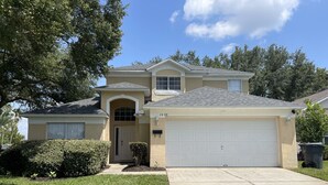 A single-story house with a garage, a front door, and a small front yard with a hedge. - 5 Bedroom Pool Home (Davenport)