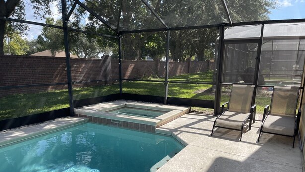 A backyard pool with a hot tub and a covered seating area. - 5 Bedroom Pool Home (Davenport)