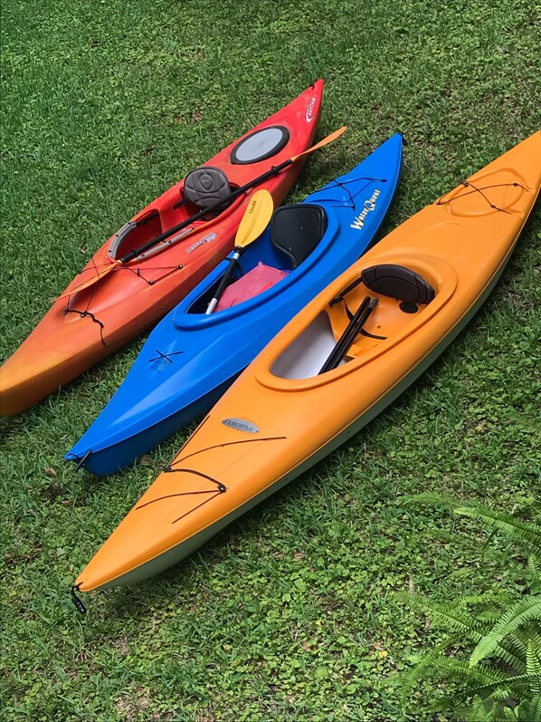 Tres kayaks sobre césped.
