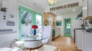 A modern kitchen with white cabinets, a green door, and a glass table with a vase. - Heart Of The City ❤️ Hot tub, ITB, NC State Cameron Village  (Raleigh)