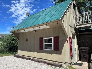 A small building with a green roof, a satellite dish, and a red door. - Santa's Shack Studio - Near Pictured Rocks (Christmas)