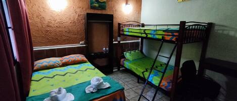 A dormitory room with bunk beds, a wardrobe, and a mirror.