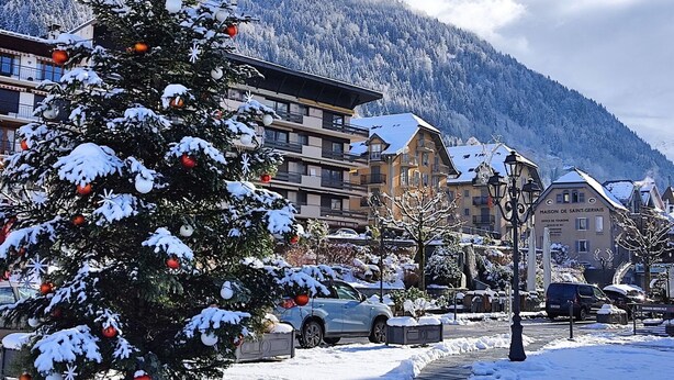 A snow-covered Christmas tree in a town square with buildings and mountains in the background. - Beautiful apartment for 4 guests with WIFI, TV and balcony (Saint-gervais-les-bains)