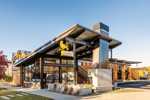 Un edificio moderno con una gran escultura de un pájaro amarillo, una escalera y un letrero que dice "FINCH".