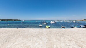 Un puerto deportivo con barcos amarrados y un área empedrada en primer plano.