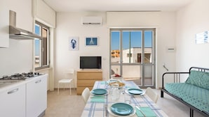 Un espacio habitable compacto con kitchenette, comedor y cama.